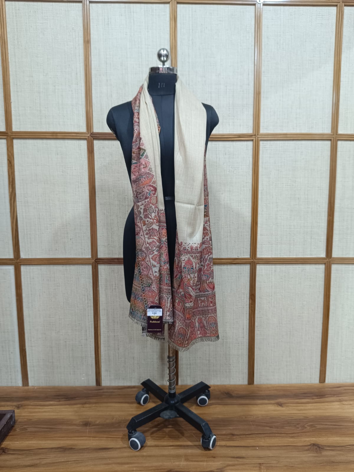 Mannequin with a patterned scarf against a wooden panel background