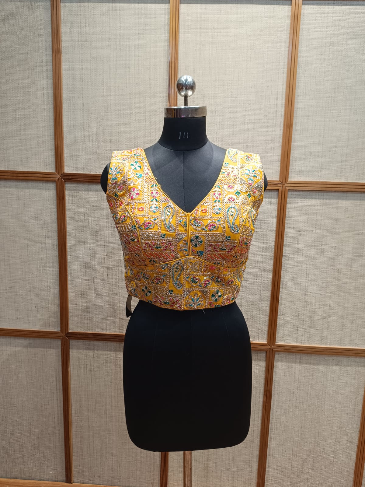 Mannequin wearing a yellow embroidered blouse
